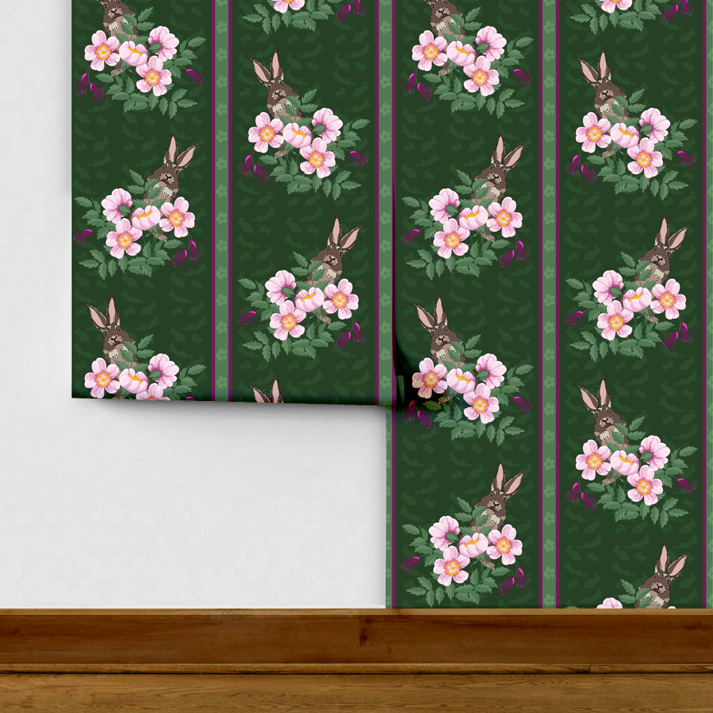 The artwork depicts a stylized brown hare partially concealed behind a cluster of green leaves and pink flowers with yellow centers. The background is dark green with subtle leafy patterns. Two vertical stripes—one dark purple and one green with small floral motifs—run along the left side, contrasting with the otherwise naturalistic elements. The composition balances the lively flora and fauna with a decorative, patterned design.